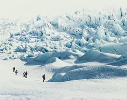 A group of travellers walk through the frozen landscape of Vatnajokull glacier.