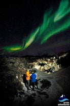 To personer ser nordlyset danse over deres hoveder.
