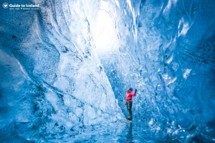 A traveler enjoys exploring the Crystal Blue Western Ice Cave in Vatnajokull Glacier.
