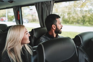 A couple is seen looking out the window in a bus.